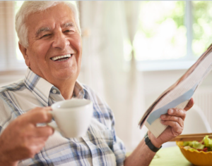 man smiling and drinking coffee